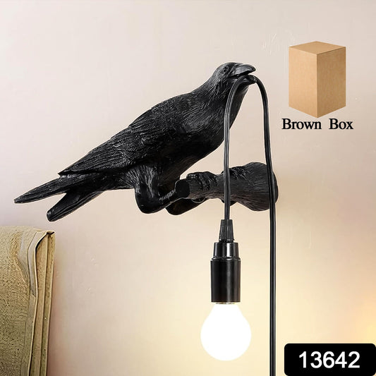 Close-up of the crow table lamp's detailed raven design and glowing Edison bulb.